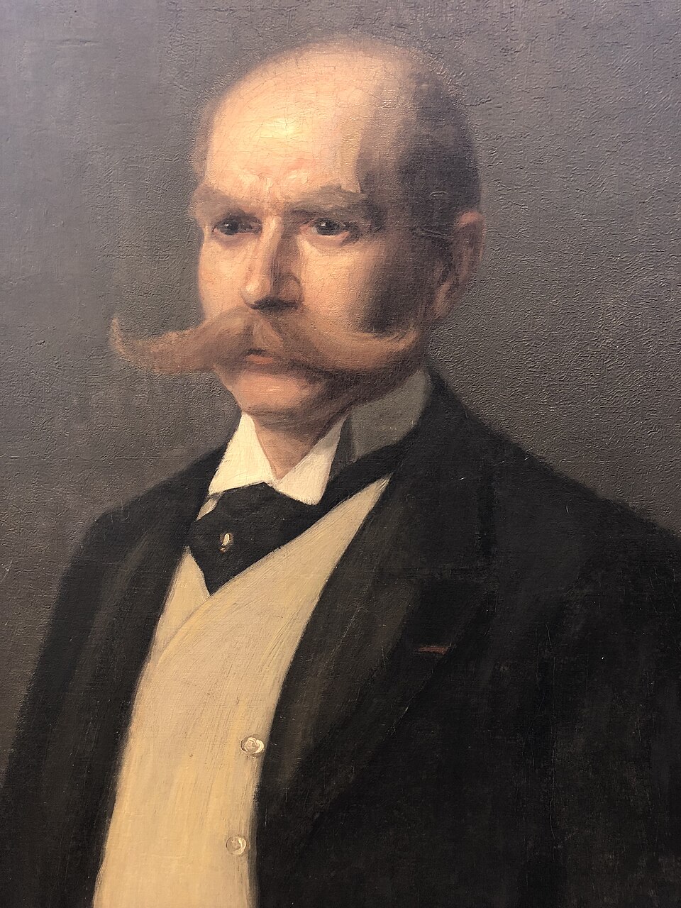 Painted portrait of Maximilian Berlitz in a dark suit with a white waistcoat and curled mustache